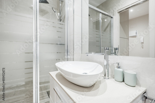 Shell-shaped white porcelain sink with walk-in shower  wall-mounted mirror
