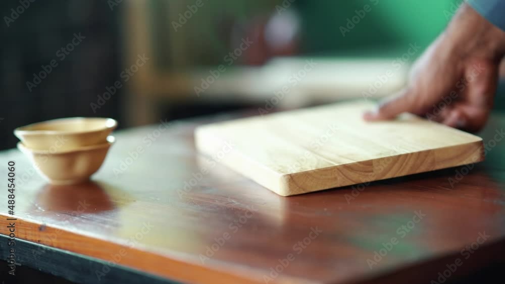 Wooden Board Being Placed On Table Beside Two Stacked Bowls Along With Salt And Pepper Shakers Wooden Board Being Placed On Table Beside Two Stacked Bowls Along With Salt And Pepper Shakers