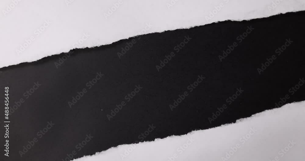 A white paper is torn on a black background.