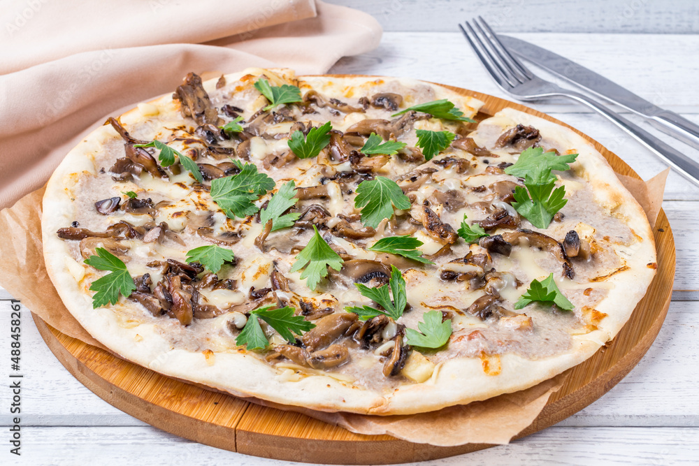 pizza with mushrooms on white wooden table