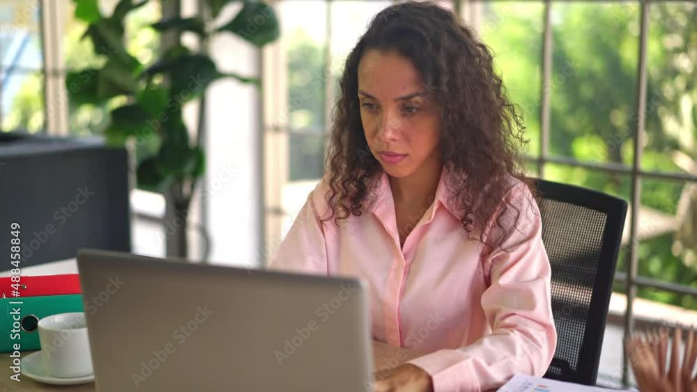 Latin woman working with hand holding card on working space at home Latin woman working with hand holding card on working space at home