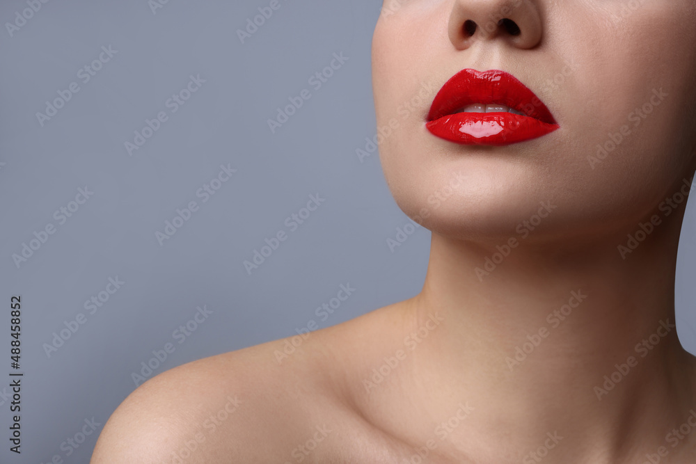 Closeup view of woman with beautiful full lips on grey background. Space for text Closeup view of woman with beautiful full lips on grey background. Space for text