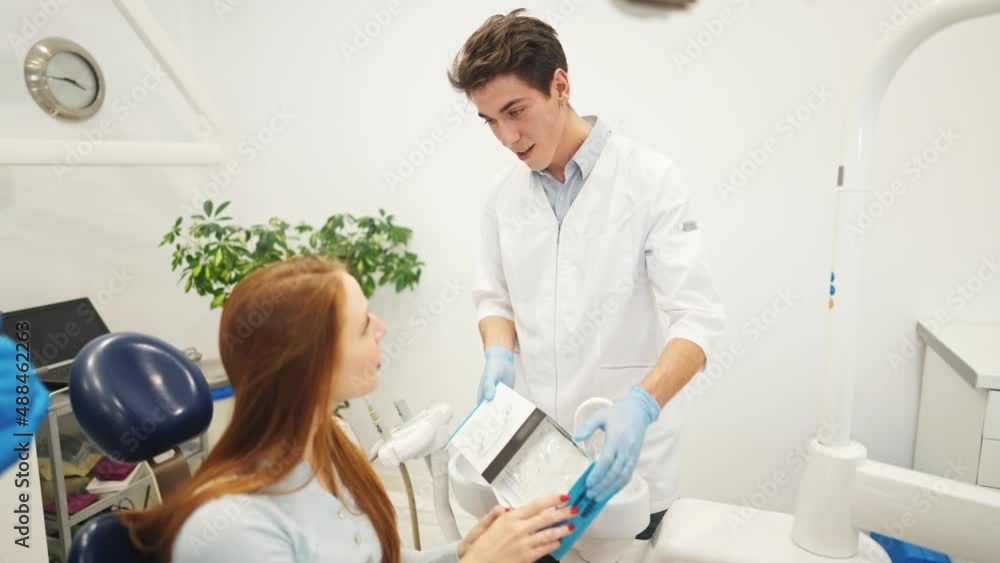 Professional dentist or orthodontist showing aligners or kappa for teeth alignment to female patient Professional dentist or orthodontist showing aligners or kappa for teeth alignment to female patient