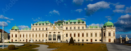Scenic view of main facade and entrance of baroque building of upper Belvedere palace with large staircase and various sculptures on sunny day, Vienna, Austria