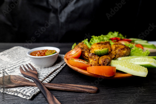 Grilled chicken with soy sauce and garnish with cucumber, tomato, lettuce, and chili