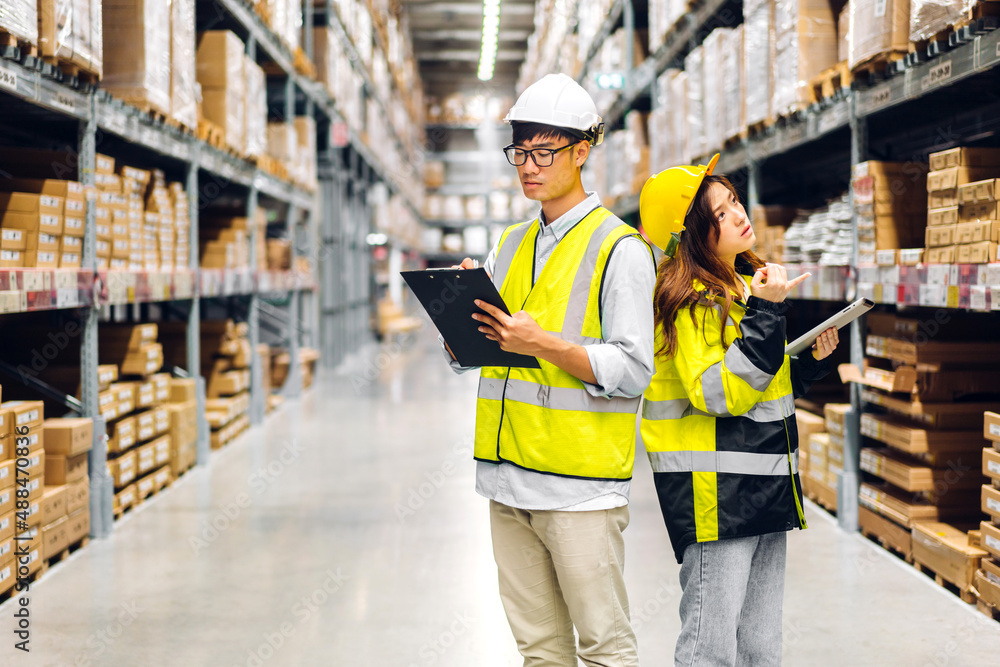 Asian two engineer team shipping order detail on tablet check goods and supplies on shelves with goods background inventory in factory warehouse.logistic industry and business export Asian two engineer team shipping order detail on tablet check goods and supplies on shelves with goods background inventory in factory warehouse.logistic industry and business export