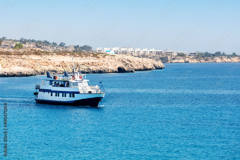 A view of white touristic ship in azzure water of the Mediterranean Sea, Cyprus. Summer vacation holiday.