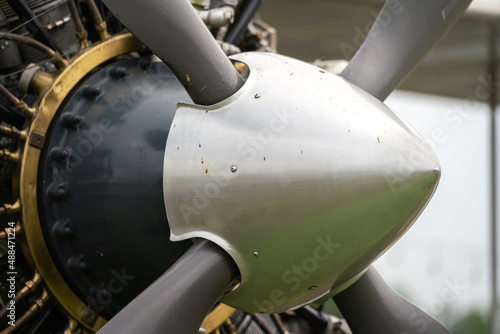 Close-up at historical WWII fighter airplane's propeller cap nose, front of the plane part. Transportation vehicle equipment, selective focus. © Nattawit