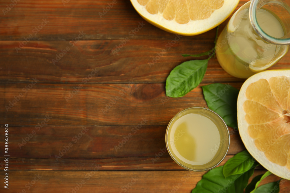 Fresh pomelo juice and fruit on wooden table, flat lay. Space for text Fresh pomelo juice and fruit on wooden table, flat lay. Space for text