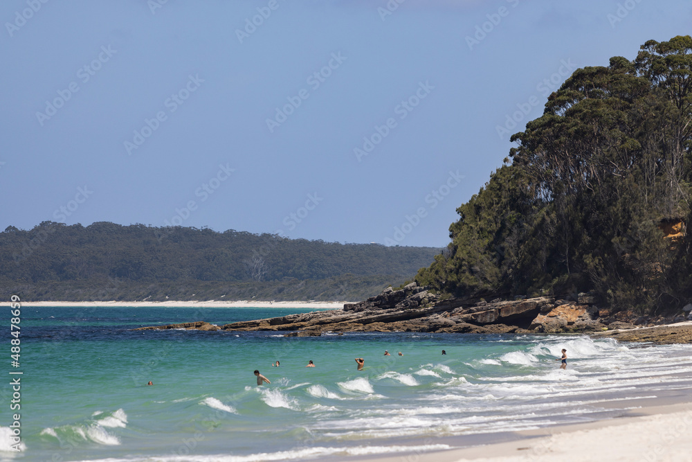 Unidentifiable people playing in the water at Hyams beach  near Jervis Bay in NSW, Australia