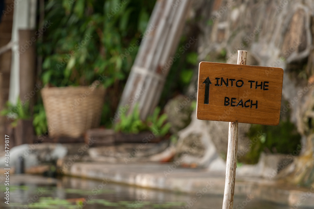 Wooden direction sign on the beach hotel 