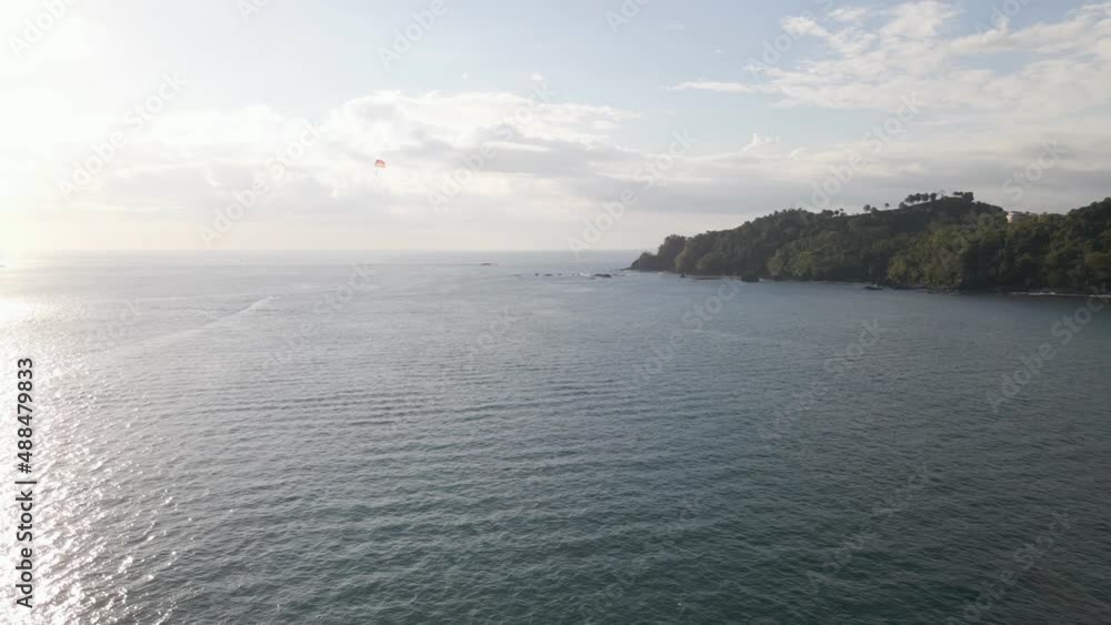 Calm, tropical coastline of Manuel Antonio Beach near Quepos, Costa Rica, as the sun sets over the ocean. Aerial pullback Calm, tropical coastline of Manuel Antonio Beach near Quepos, Costa Rica, as the sun sets over the ocean. Aerial pullback
