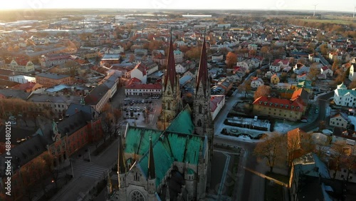 Roof And Spires Of Historic Skara Cathedral In Skara, Sweden At Sunrise. aerial drone orbit photo