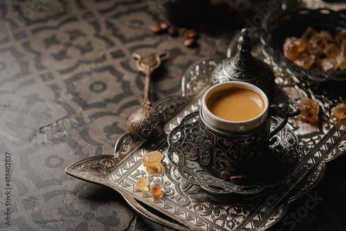 Coffee in metal Turkish traditional cup and coffee beans on dark tile background photo