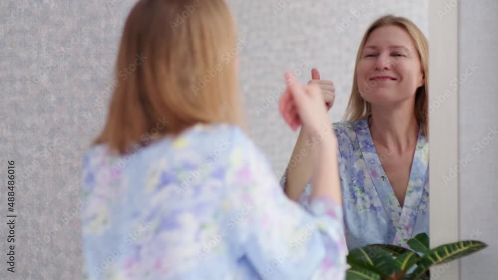 Happy adult woman dancing in front of the mirror in bedroom. Video 4K, slow motion. Happy adult woman dancing in front of the mirror in bedroom. Video 4K, slow motion.