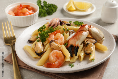 Delicious pasta with sea food served on light grey table