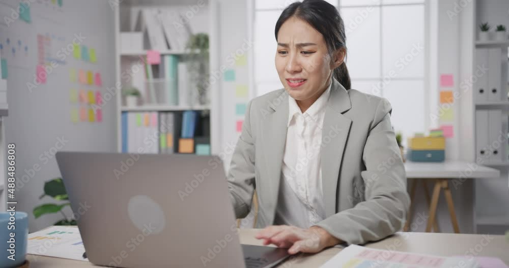 Young Asia businesswoman sitting on desk crazy with overworked stress angry massive work scream at office. Lady mad trouble of work from employee make fail work finance report, Work mental health. Young Asia businesswoman sitting on desk crazy with overworked stress angry massive work scream at office. Lady mad trouble of work from employee make fail work finance report, Work mental health.