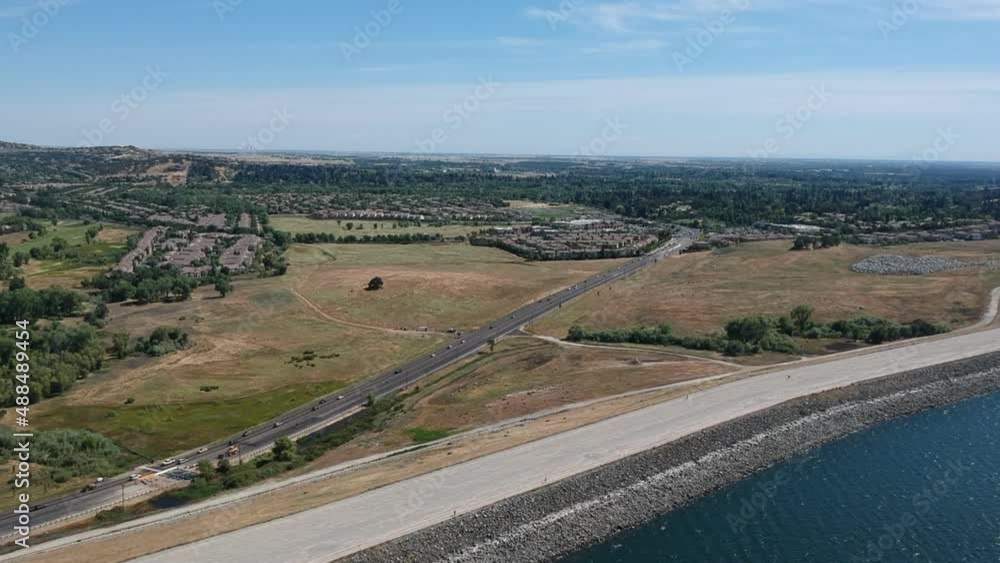 Aerial view of cars driving on the highway next to Folsom lake shoreline Aerial view of cars driving on the highway next to Folsom lake shoreline