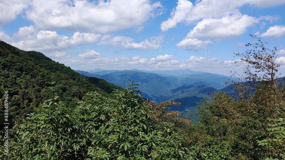 Naklejka premium Mountains that extend far under the white clouds.