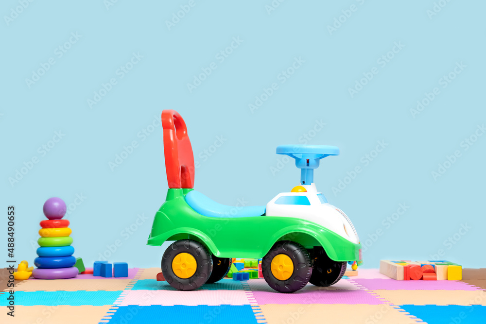 Toy children's plastic car in the playroom on a blue background