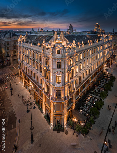 Budapest, Hungary - Aerial view of a renovated illuminated luxury collection hotel near Ferenciek tere after sunset at downtown Budapest with colorful golden and blue sky on a summer night