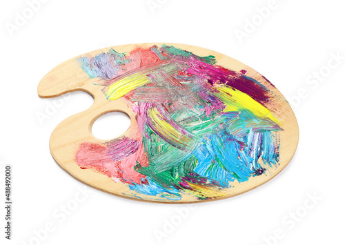 Wooden artist's palette with mixed paints isolated on white