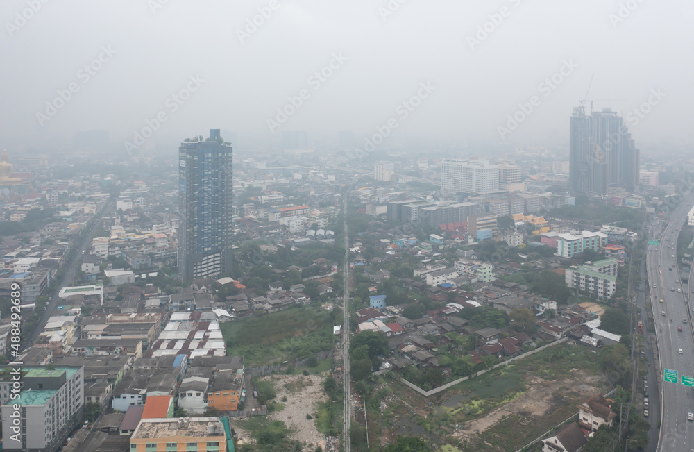 Obraz premium Aerial view of highway street road at Bangkok Downtown Skyline, Thailand. Financial district and business centers in urban city in Asia. Skyscraper buildings with fog. Air pollution pm2.5