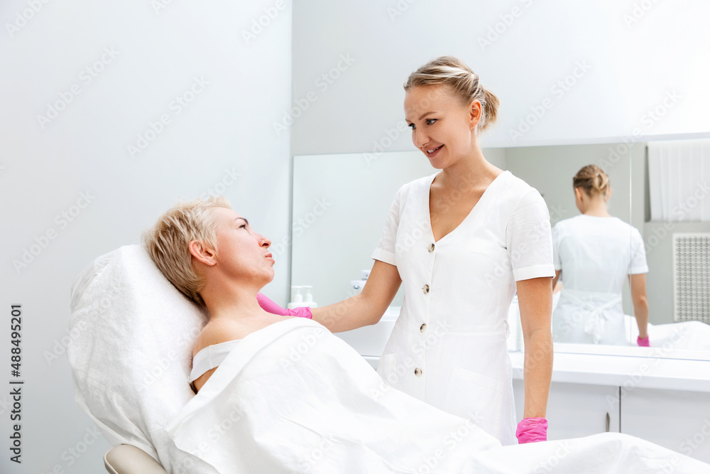 Obraz premium Adult woman at a reception with a professional cosmetologist in a beauty salon. The concept of cosmetology and aesthetic medicine