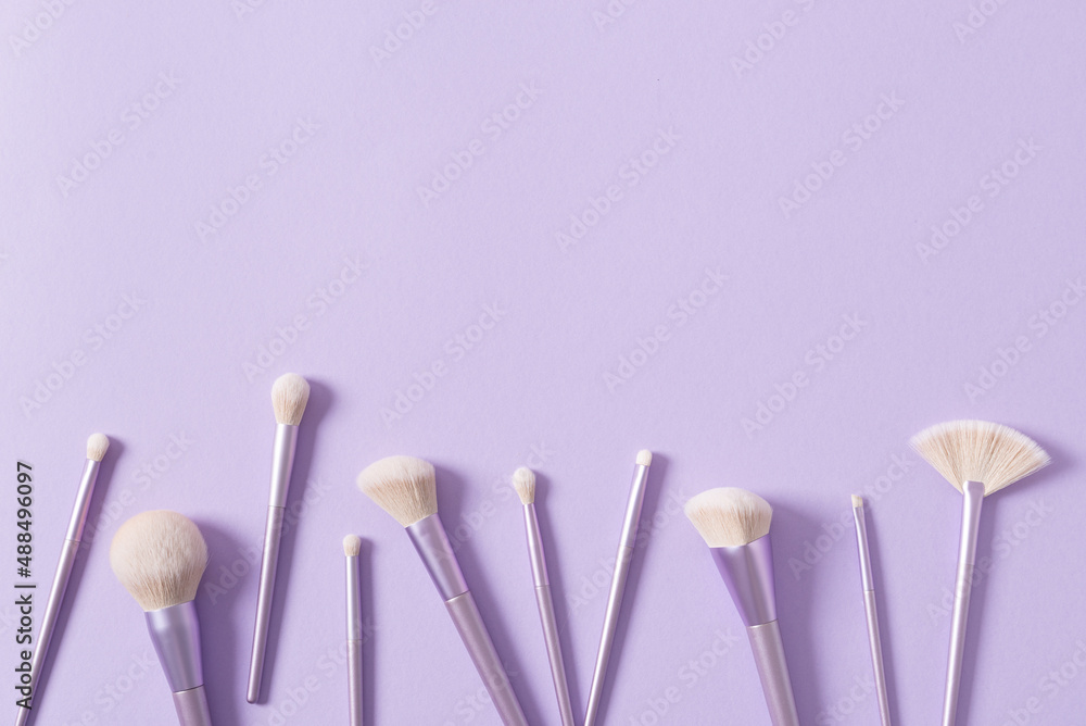 Makeup brushes background. Set of glamour makeup brushes on a pastel violet background. Magazines, social media. Visagist tools. Top view, copy space. Creative flat lay. Cosmetics products sale Makeup brushes background. Set of glamour makeup brushes on a pastel violet background. Magazines, social media. Visagist tools. Top view, copy space. Creative flat lay. Cosmetics products sale