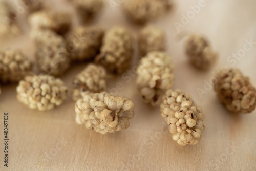 dried mulberry fruit. isolated on wooden surface.