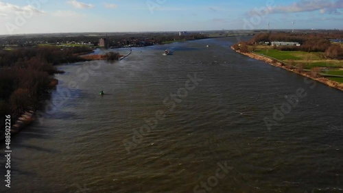 Aerial Over Oude Maas Rising To Reveal Zwijndrecht Landscape With Colorado Cargo Ship In Distance photo