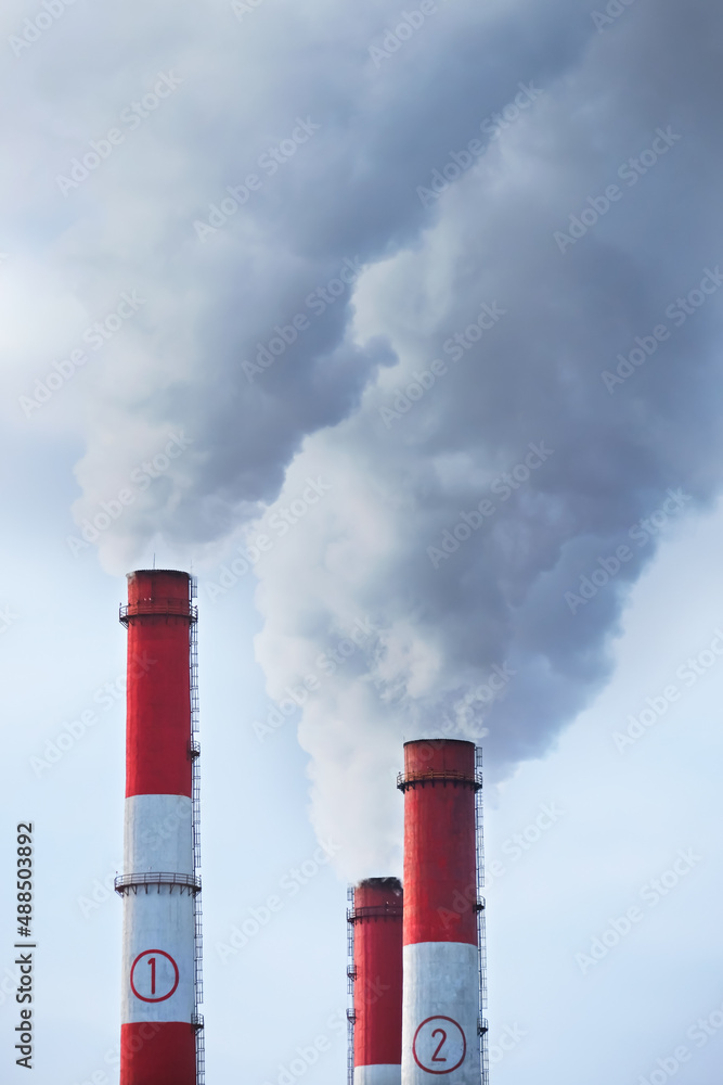 Thick dark smoke comes from the CHP pipes. Copy space. High quality photo
