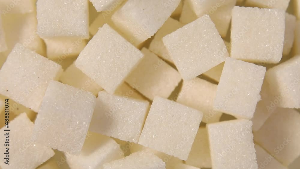 Rotation macro white sugar cubes close up texture background, diet health risks related to diabetes and calorie intake Rotation macro white sugar cubes close up texture background, diet health risks related to diabetes and calorie intake