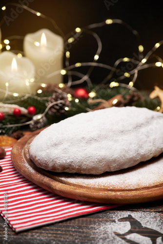 Traditional Christmass stollen cake with marzipan and dried fruit on rustic background