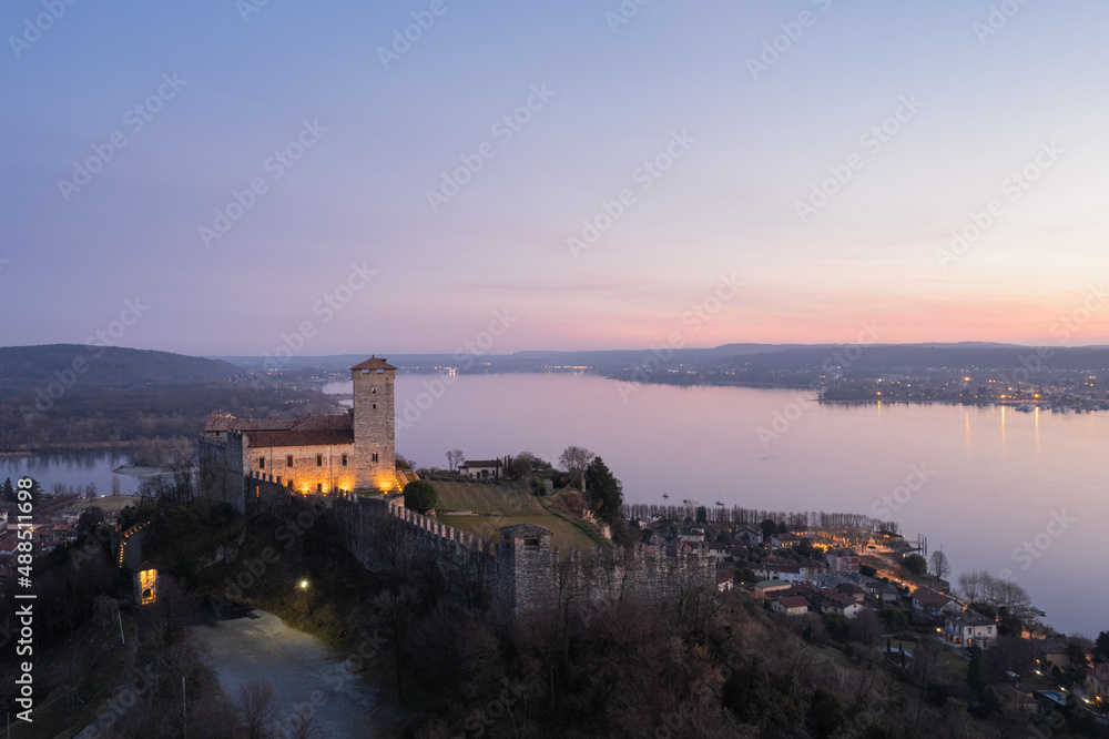Angera Castle at sunset aerial view with Arona city in the background.