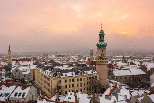 Aerial view about the 58 meters high iconic Fire tower and Sopron city hall in the heart of the city. Winter cityscape with snowy rooftops.