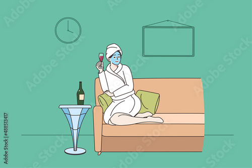 Happy woman in bathrobe relax on sofa in spa with glass of champagne enjoy leisure weekend alone. Smiling girl with mask on face have dayoff in saloon. Beauty day concept. Vector illustration.  photo