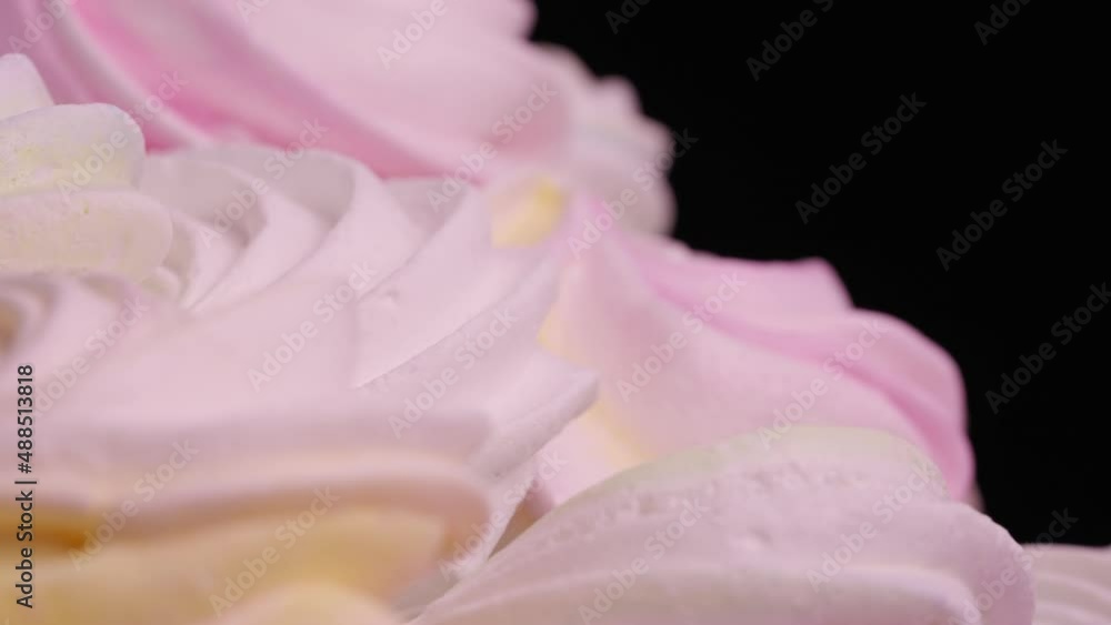 Twirl of sweet meringue rotating on black background. French sweets cookies made from protein and sugar. Close up shot of candy dessert yellow, pink and purple color. Slow motion ready, 4K at 59.94fps Twirl of sweet meringue rotating on black background. French sweets cookies made from protein and sugar. Close up shot of candy dessert yellow, pink and purple color. Slow motion ready, 4K at 59.94fps
