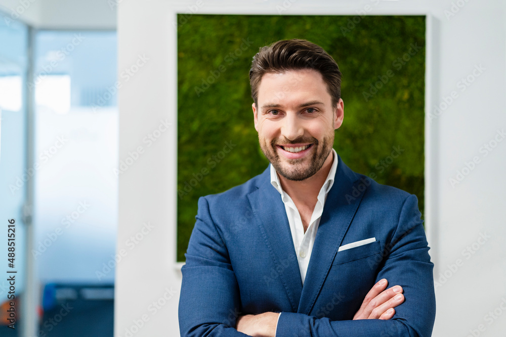Smiling businessman with arms crossed at office Smiling businessman with arms crossed at office