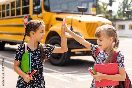 Education: Smiling Student Friends Ready For School next to school bus