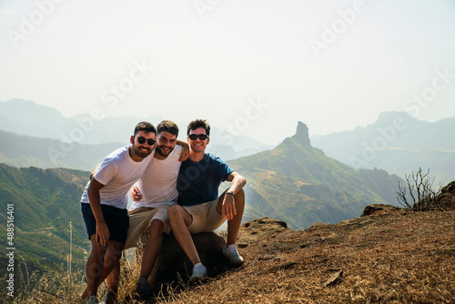 Happy young friends sitting on rock at Degollada de Becerra, Spain photo