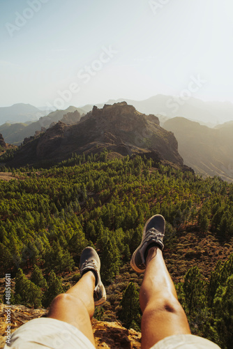 Man sitting on mountain at Roque Nublo, Grand Canary, Spain photo