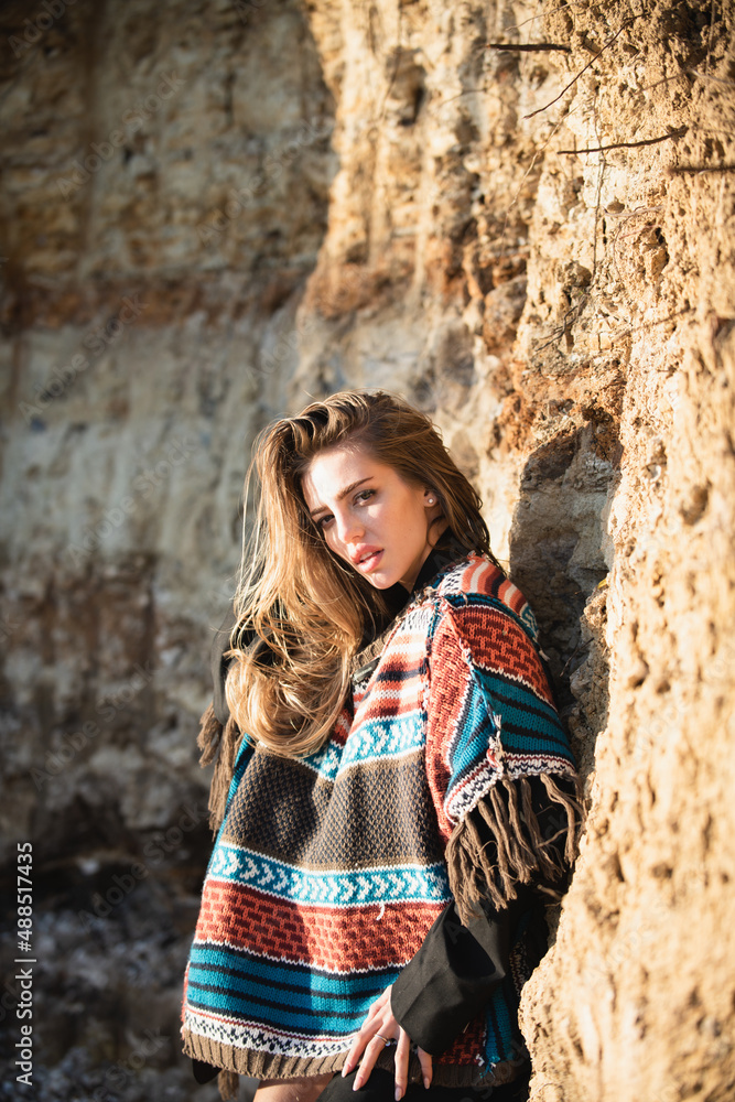 Beautiful woman in boho style sweater. Attractive woman in fashion outfit outside. Outdoor fashion photo of young beautiful lady enjoying spring.