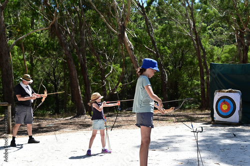 Canvas Print Father and daughters practicing archery together