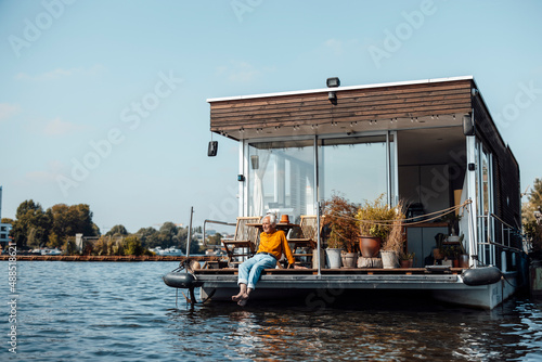 Senior man relaxing at houseboat on sunny day photo