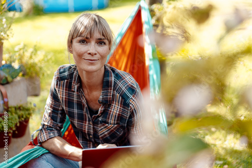 Woman with laptop sitting in hammock photo