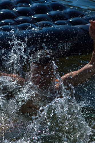 young man jumping into the river in the summer on a hot day © yurii oliinyk