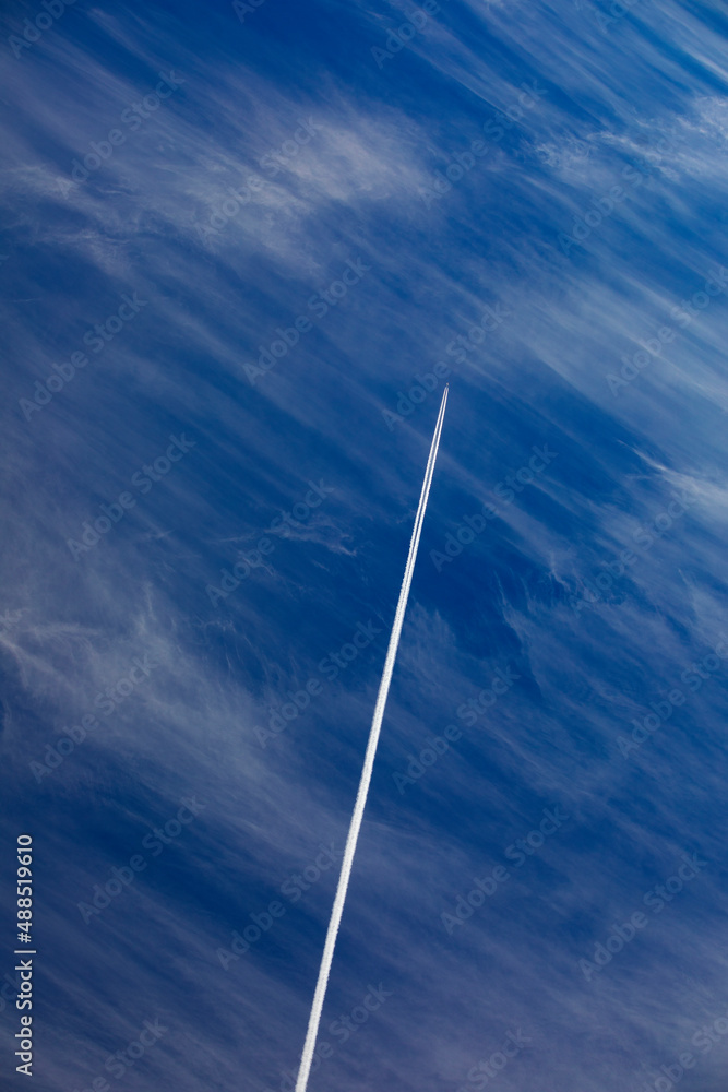 Airplane leaving vapor trail against blue sky Airplane leaving vapor trail against blue sky