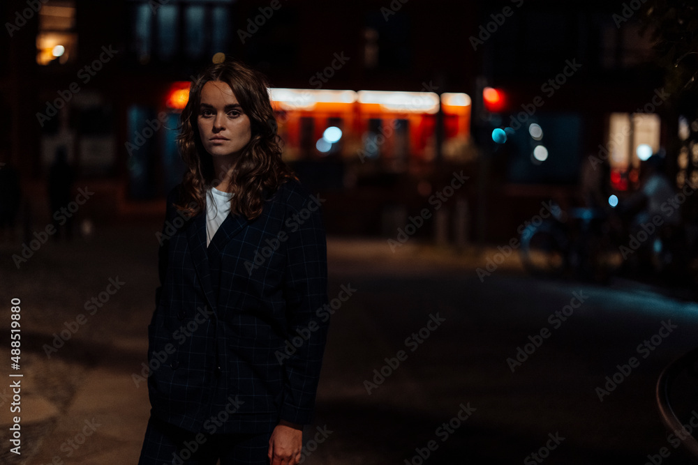 Serious woman on city street at night Serious woman on city street at night