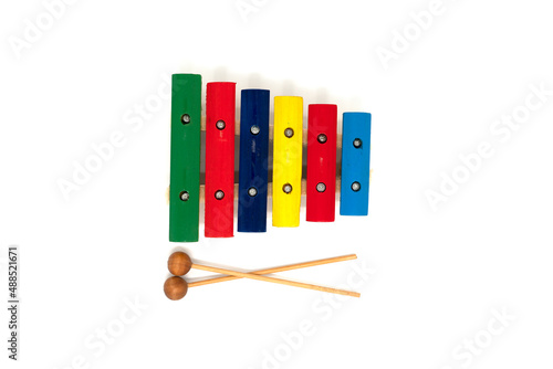 Rainbow colored wooden toy xylophone with two sticks on white background